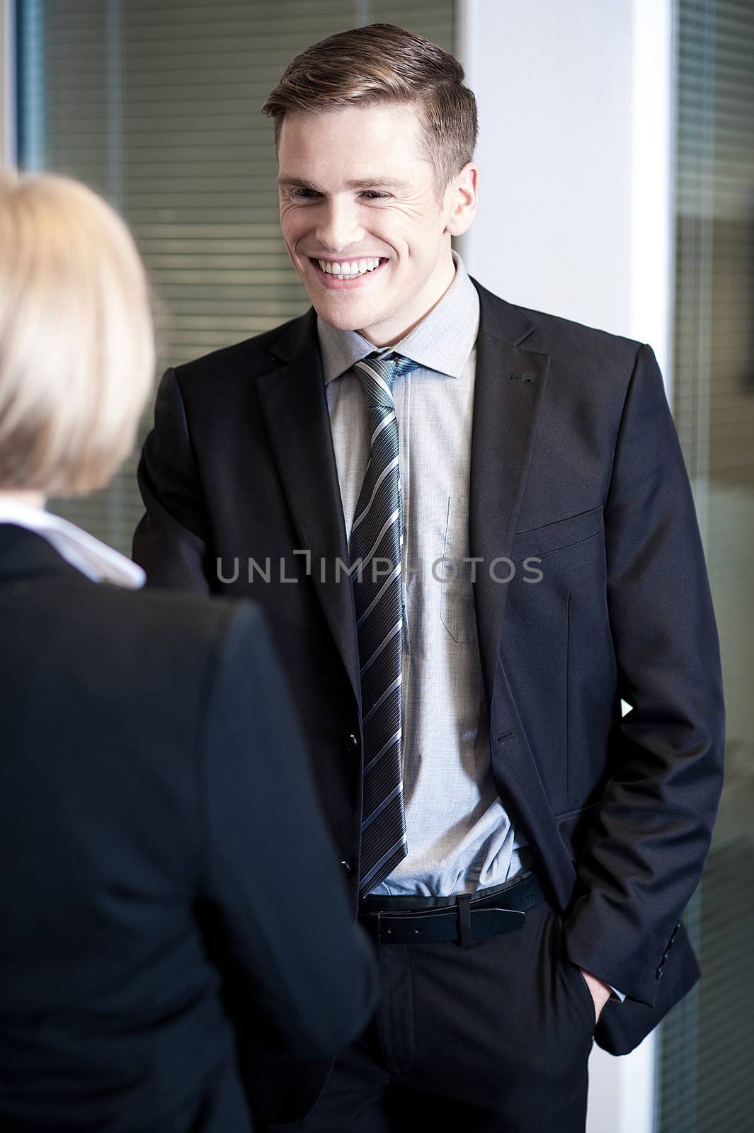 Two cheerful business colleagues communicating