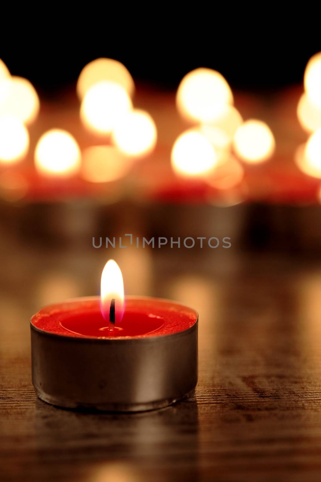 red candle on a wooden floor