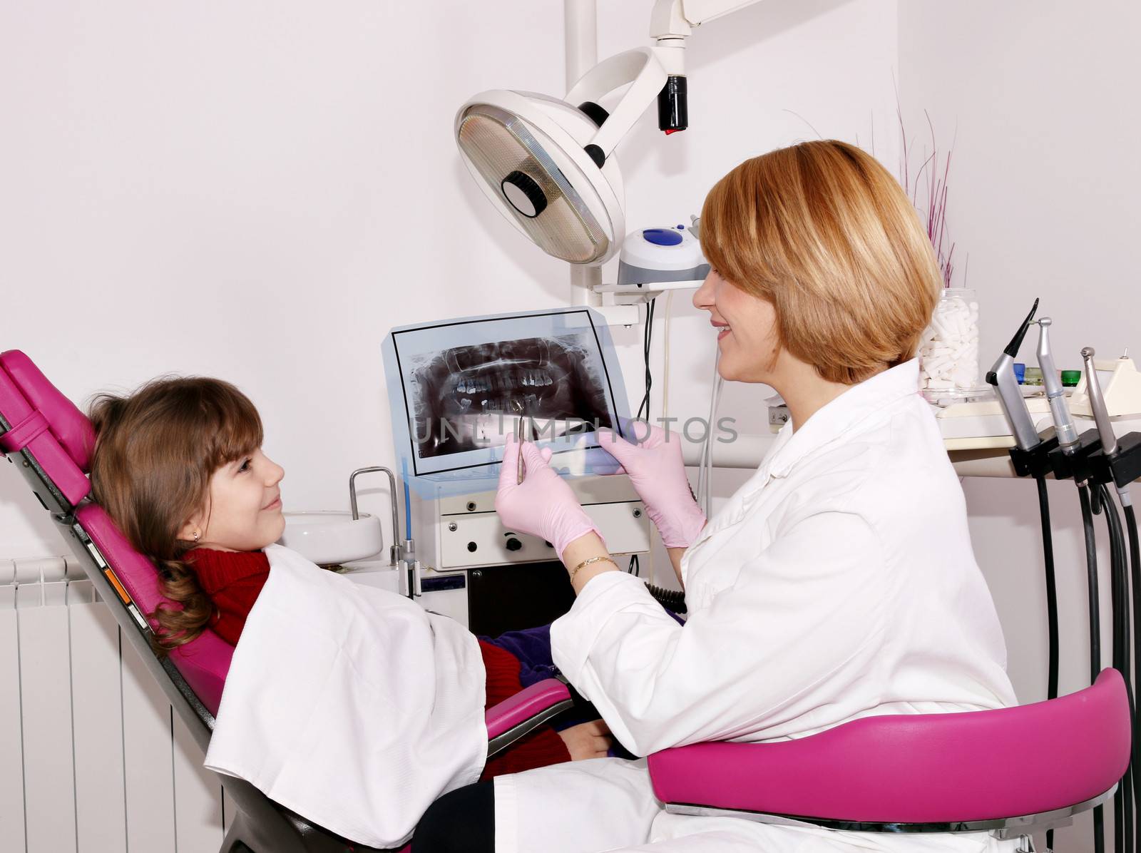 dentist showing x-ray to a little girl  by goce