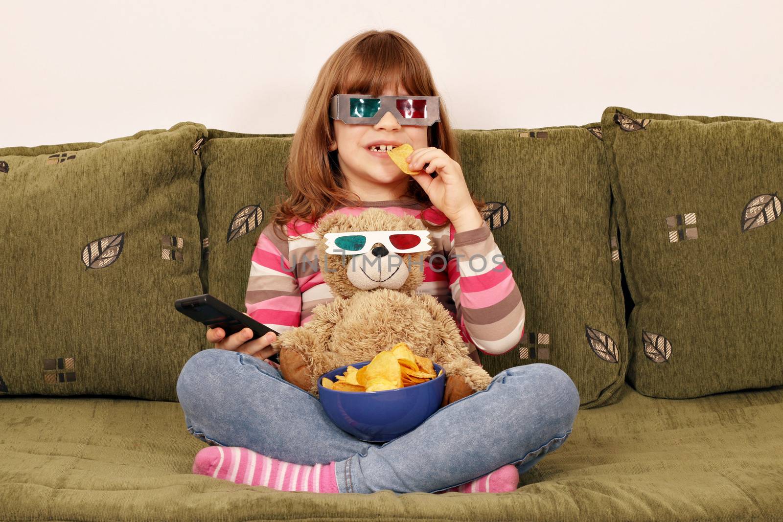 little girl with 3d glasses eat chips and watching tv by goce
