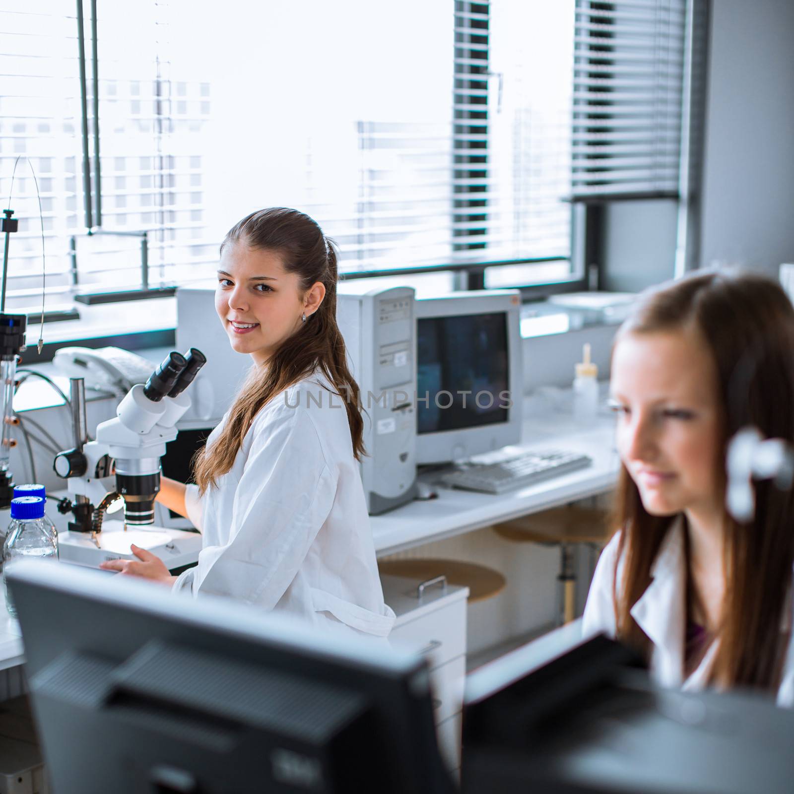 Two young researchers carrying out experiments in a lab by viktor_cap