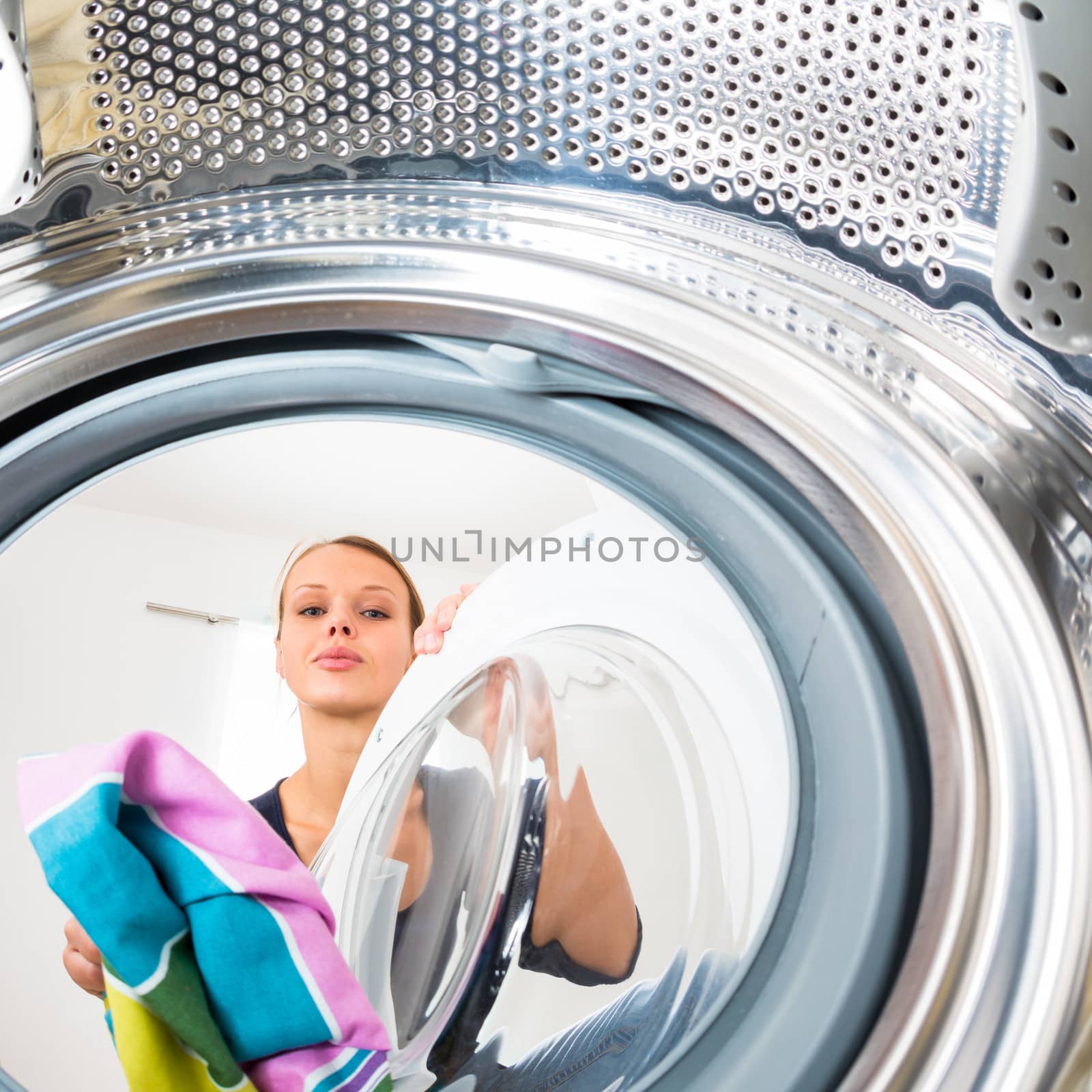 Housework: young woman doing laundry by viktor_cap