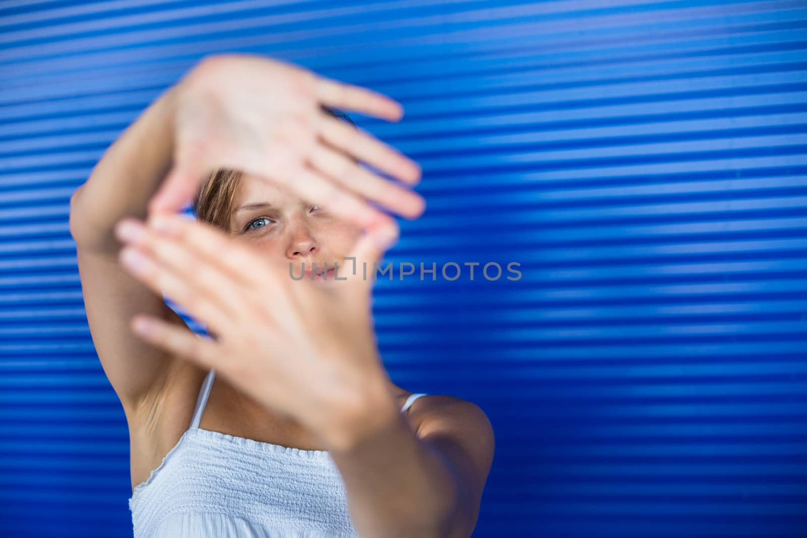 Pretty, young woman making a photo composing/shooting gesture with her hands