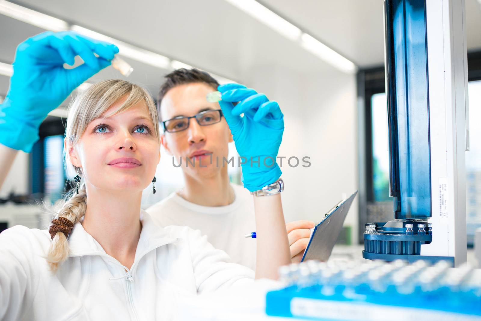 Two young researchers carrying out experiments in a lab by viktor_cap