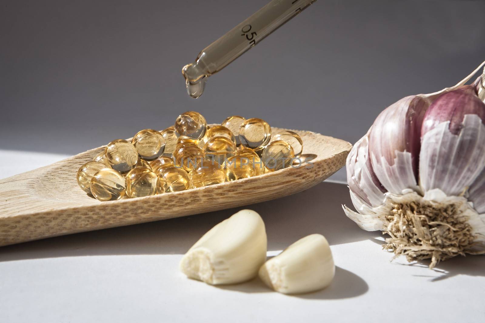 Glass dropper on capsules of garlic oil, Garlic oil capsules, vitamins d pills 