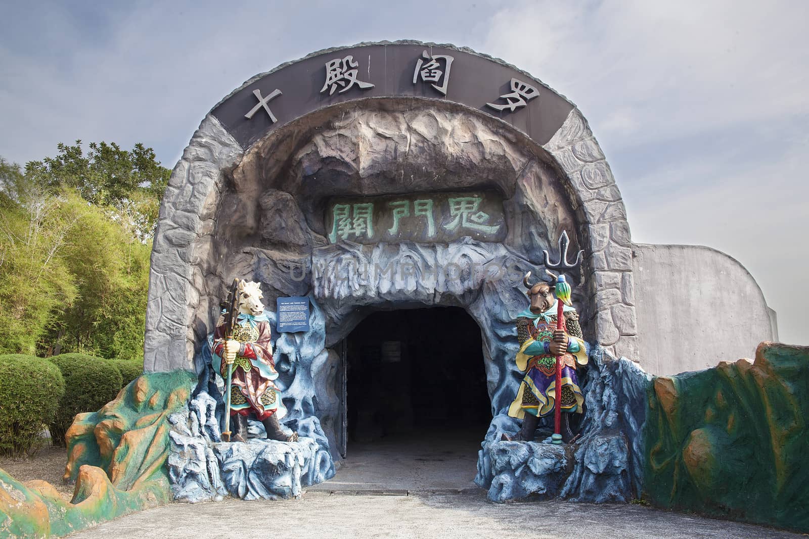 SINGAPORE - FEBRUARY 1, 2014: Entrance to the Ten Courts of Hell with Ox-Head and Horse-Face Guradians at Haw Par Villa Theme Park. This theme park contains over 1,000 statues and 150 giant dioramas depicting scenes from Chinese mythology, folklore, legends, and history.