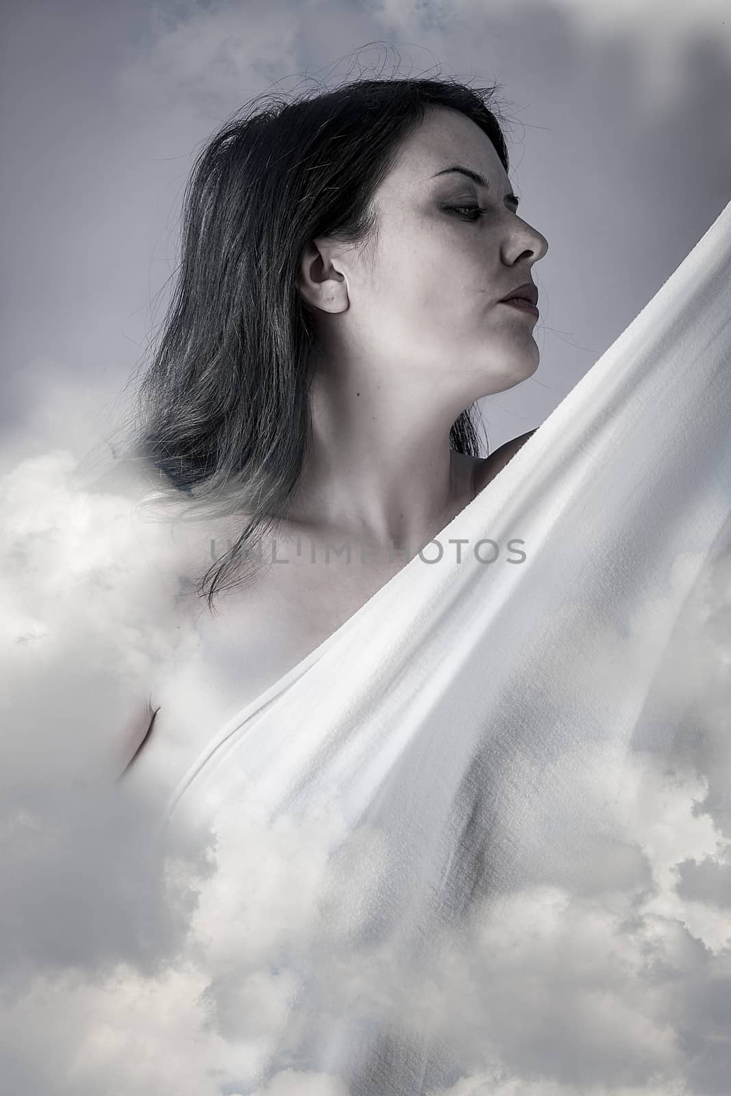 Beautiful woman in clouds, mithology concept. Brunette with long hair and white dress.