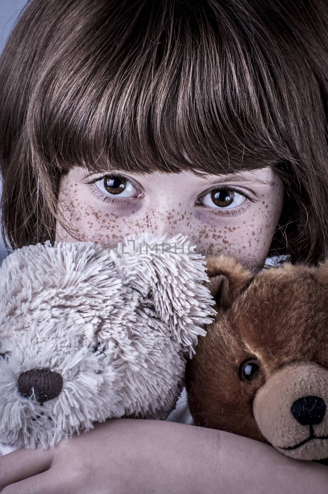 girl with freckles and two stuffed animals, teddy bears