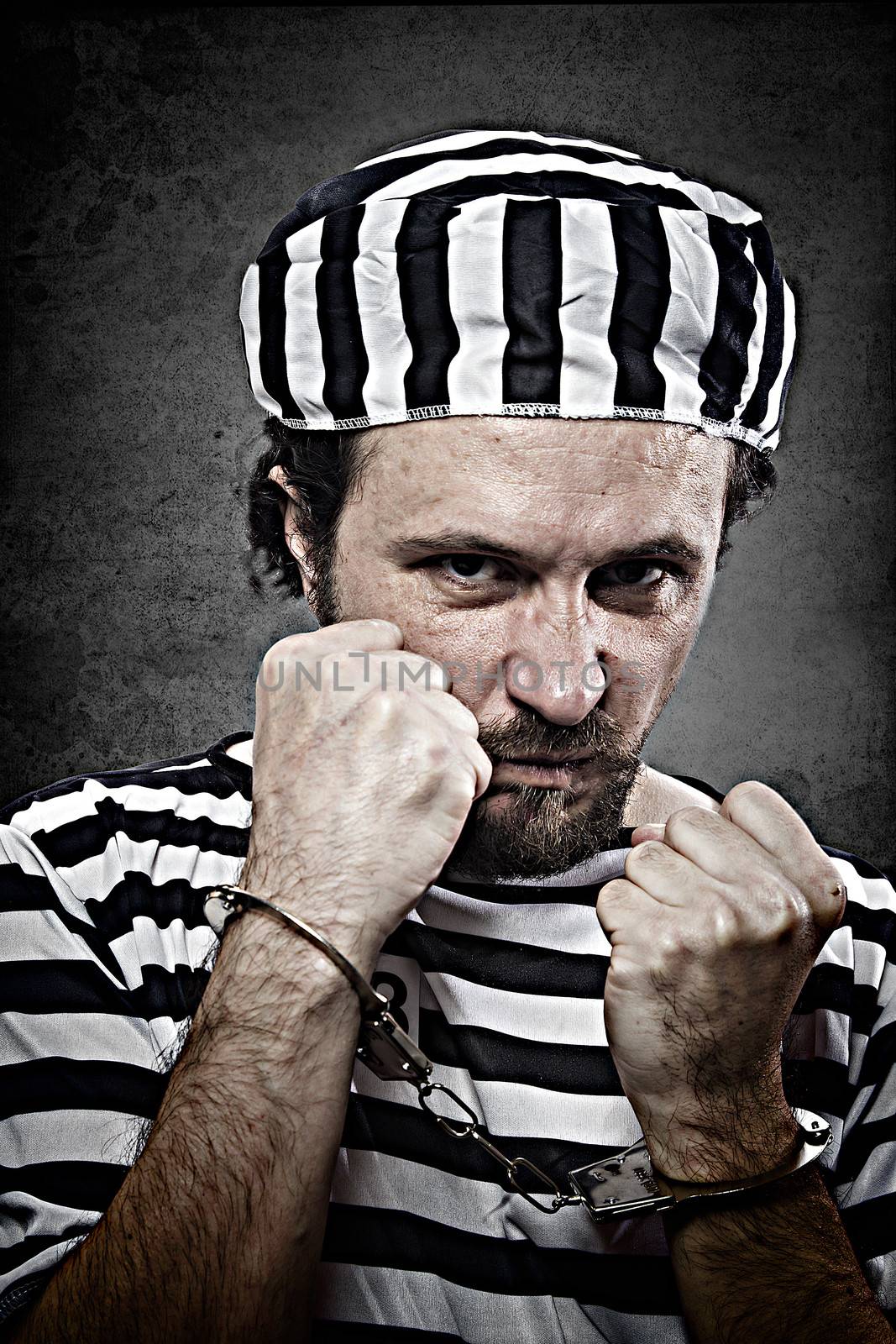 Desperate, portrait of a man prisoner in prison garb, over white background