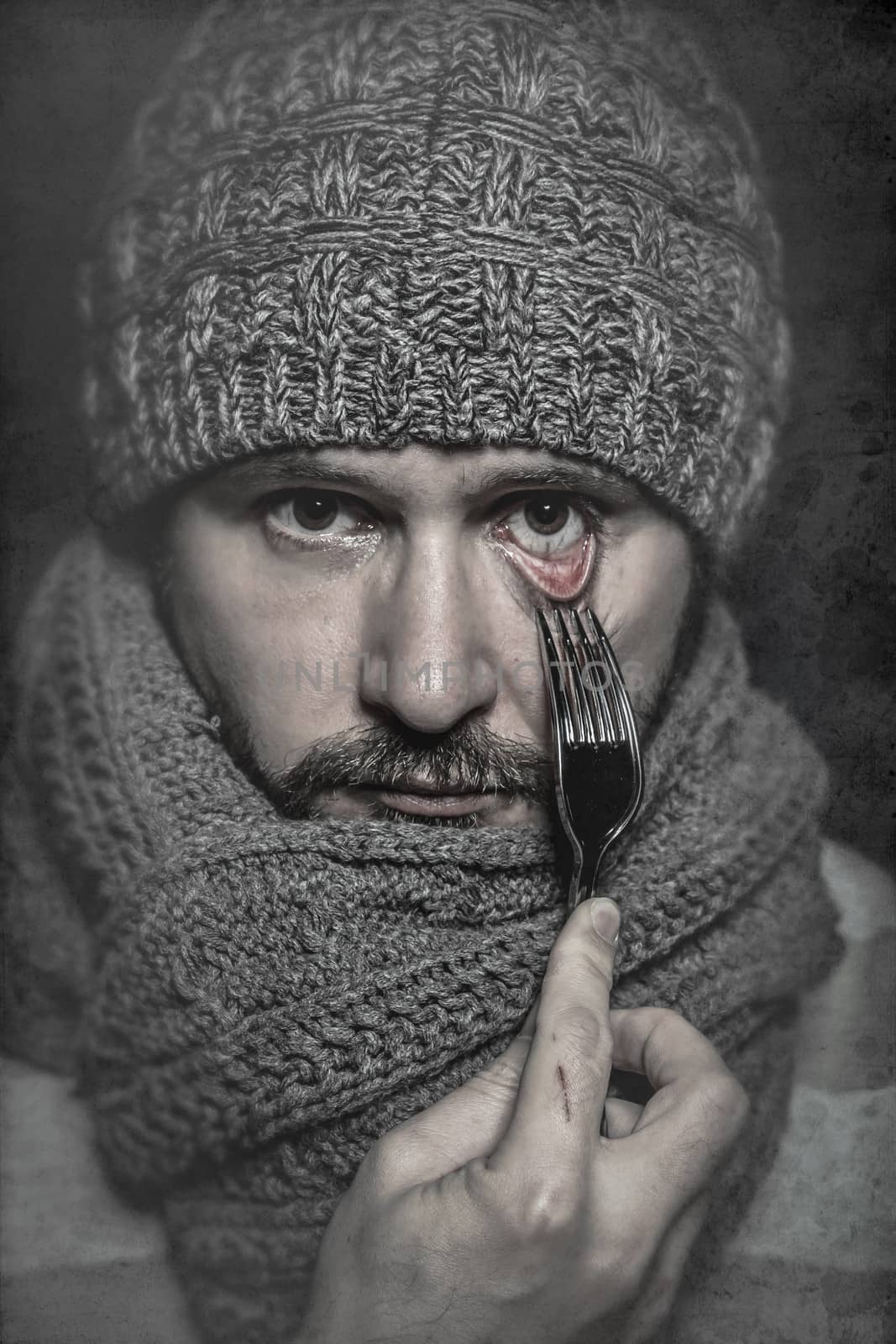 man with a fork in his eye, concept danger, risk