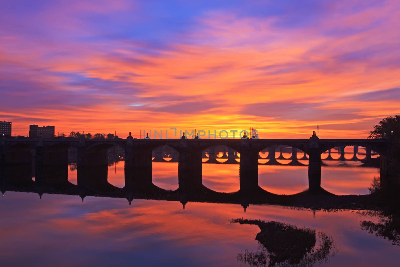 A colorful sunrise over the many old bridges crossing the Susquehanna River in Harrisburg, Pennsylvania, USA.