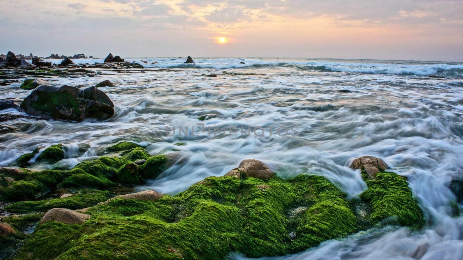Beautiful landscape with green moss, stone, sunrise on sea by xuanhuongho