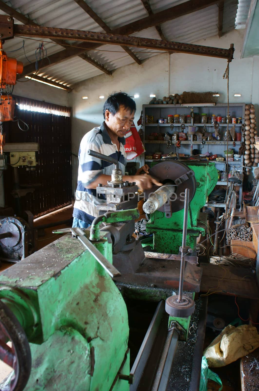 BINH THUAN, VIETNAM- JAN 21: Mechanic working with machine in private mechanical workshop, this place repair mechanic part for fishing boat in Viet Nam, Jan 21, 2014