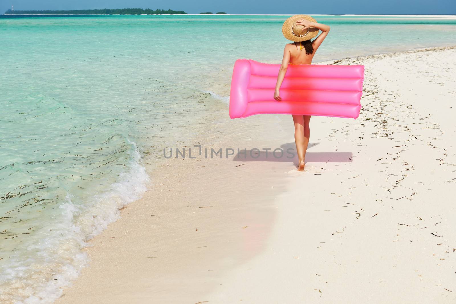 Woman with pink inflatable raft at the beach by haveseen