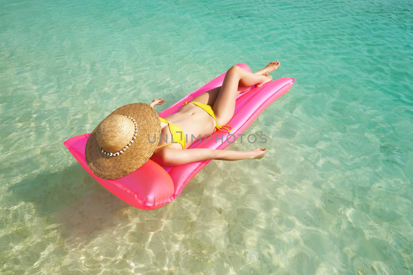 Woman relaxing on inflatable mattress at the beach