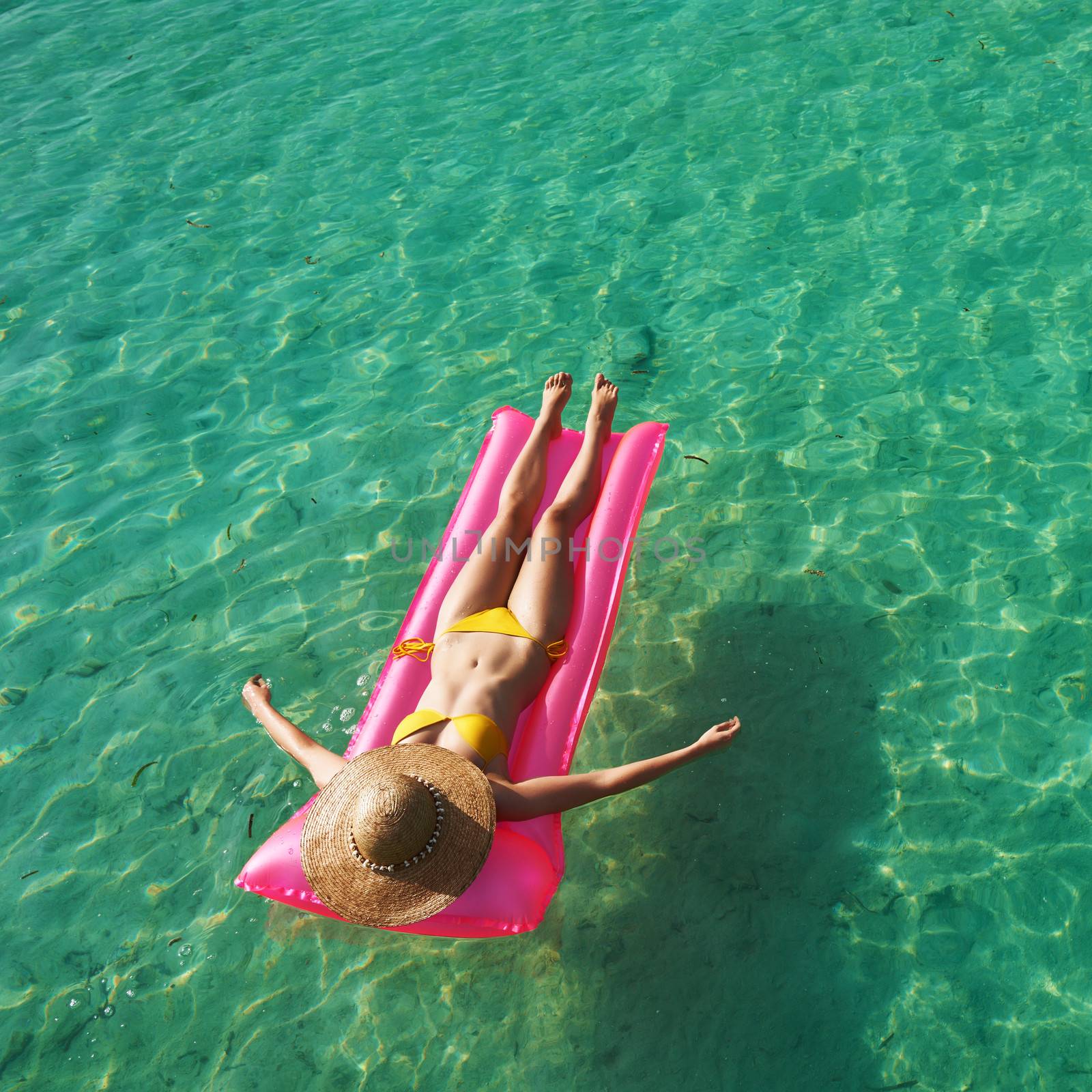 Woman relaxing on inflatable mattress at the beach