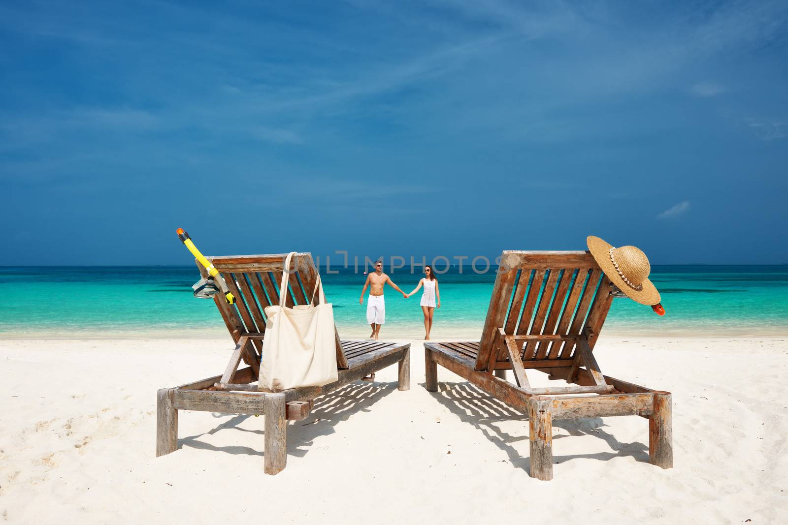 Couple in white running on a tropical beach at Maldives