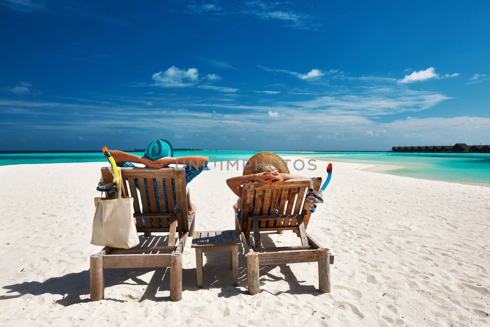 Couple relax on a tropical beach at Maldives