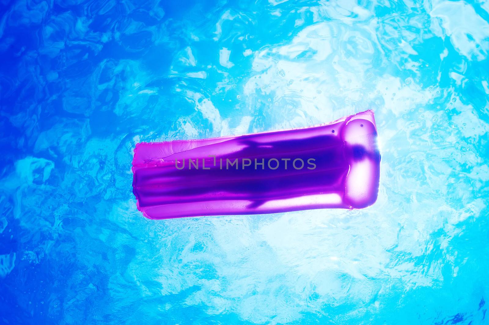 Woman relaxing on inflatable mattress at the beach, view from underwater