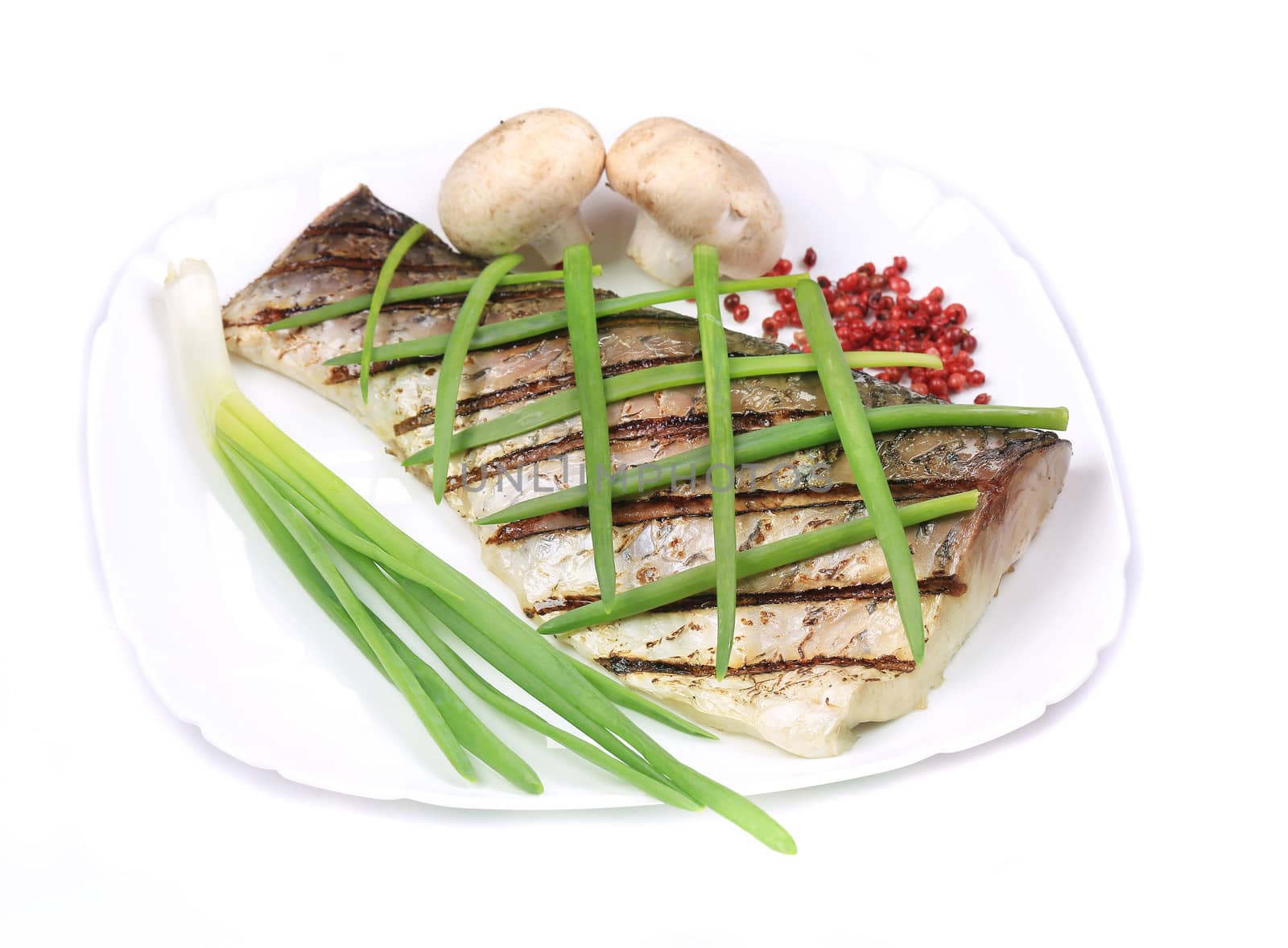 Grilled carp fillet on plate with onion. Isolated on a white background.