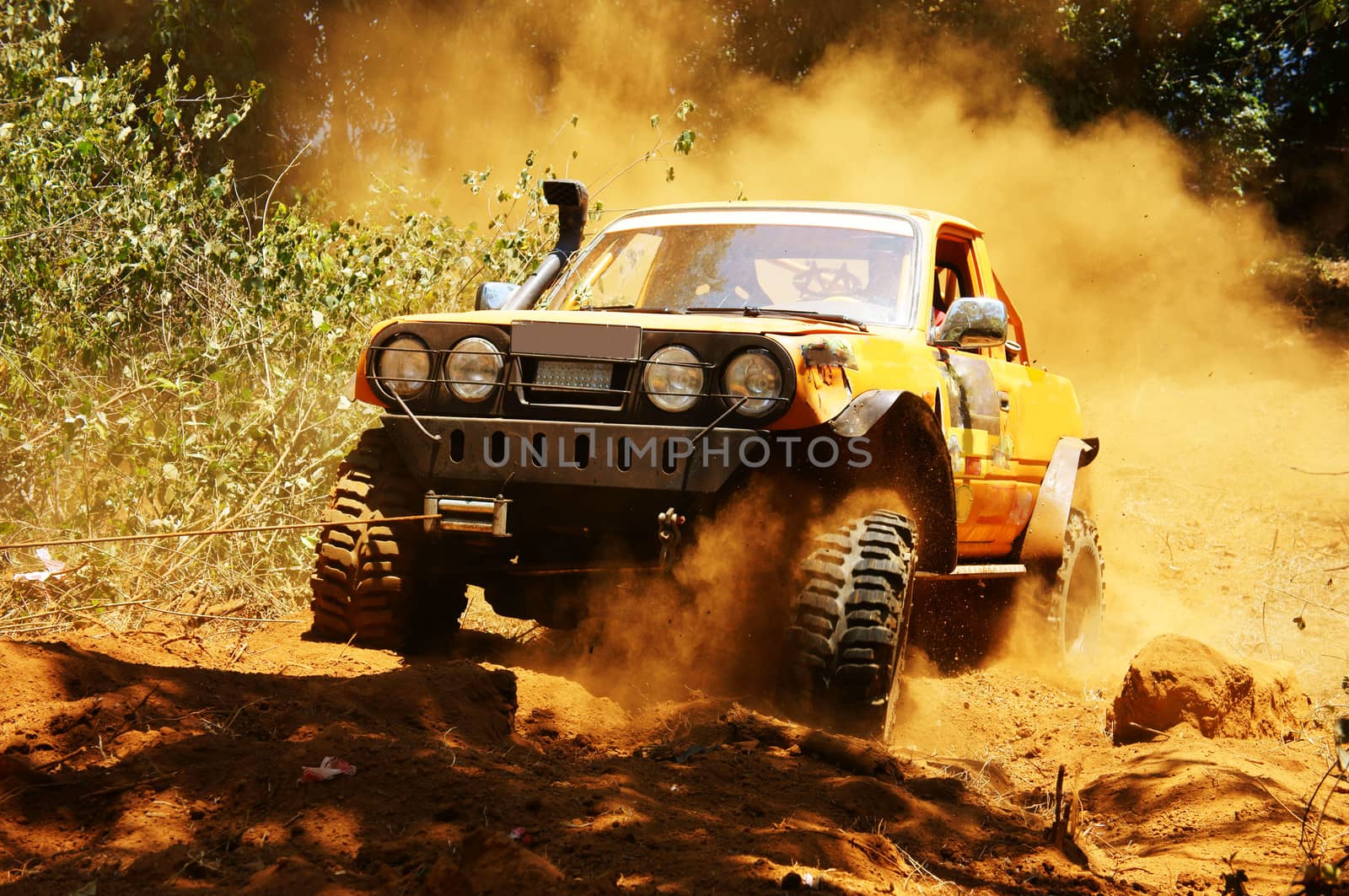 Racer at terrain racing car competition, the car try to cross extreme off road with red earth,  wheel make splash of soil and dusty air, competitor  adventure in championship spirit 