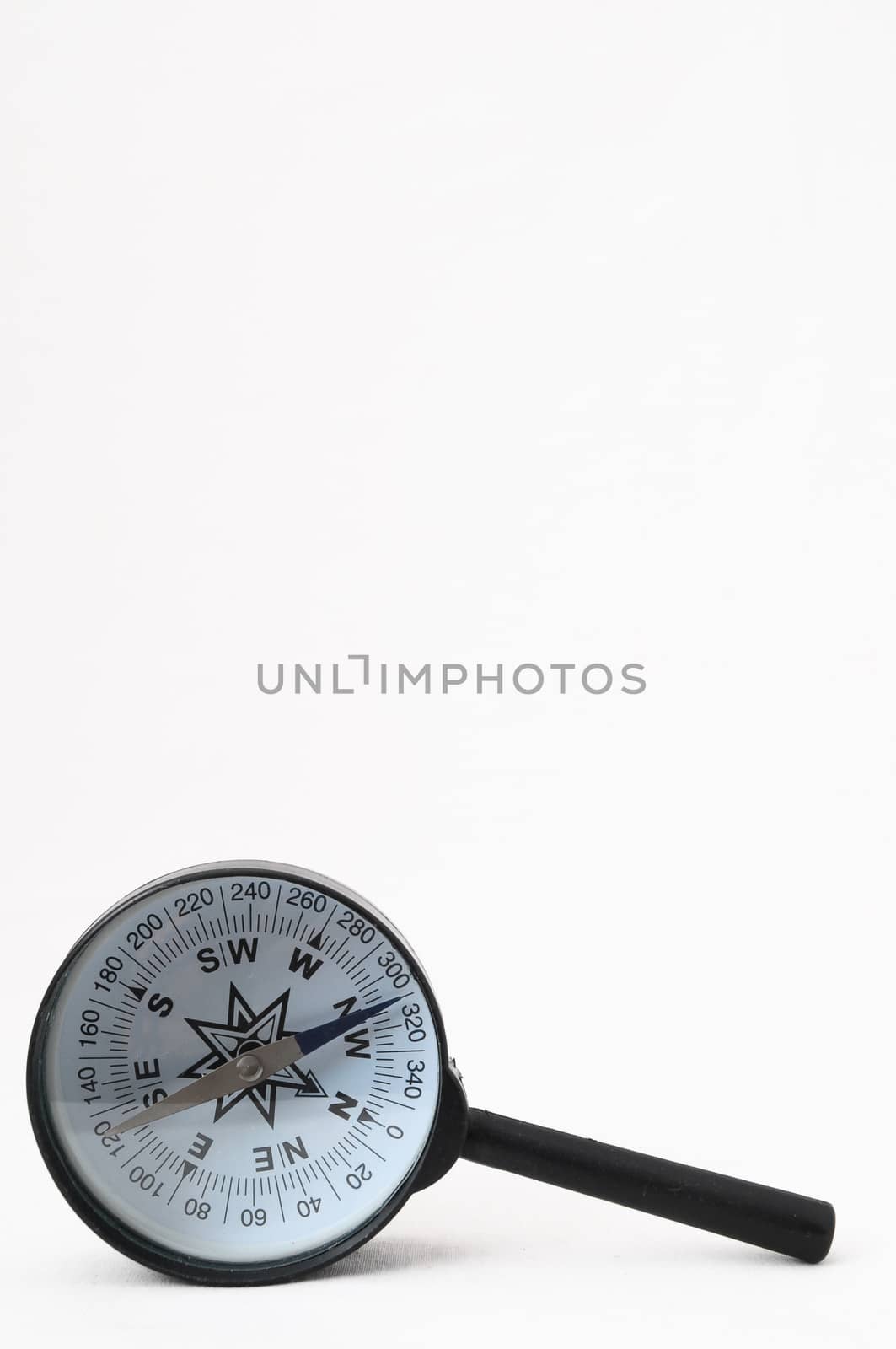 Orientation Concept - Analogic Compass and Loupe on a White Background