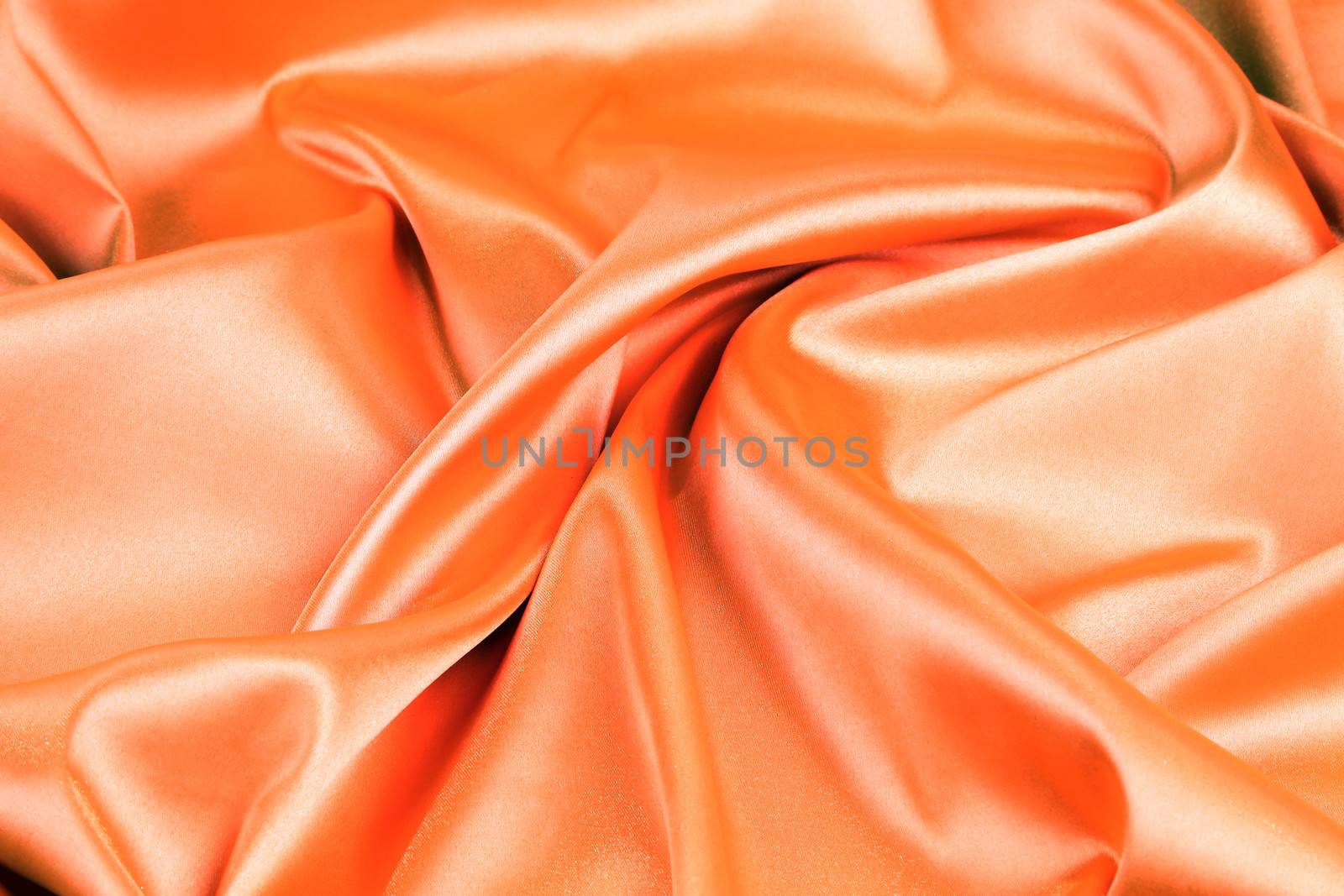 orange silk background with some soft folds and highlights