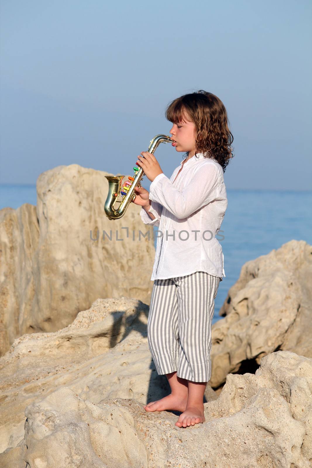 beautiful little girl play saxophone