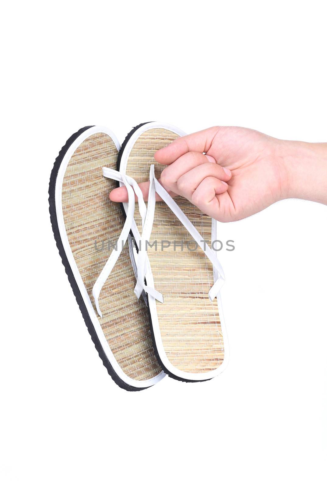 Pair of striped flip-flop sandals in hand. Isolated on a white background