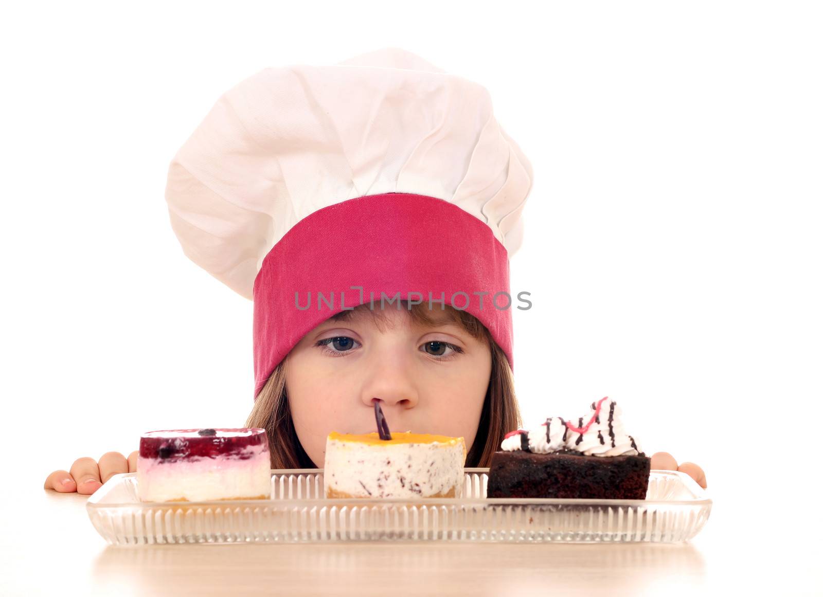 little girl cook looking at cookies by goce