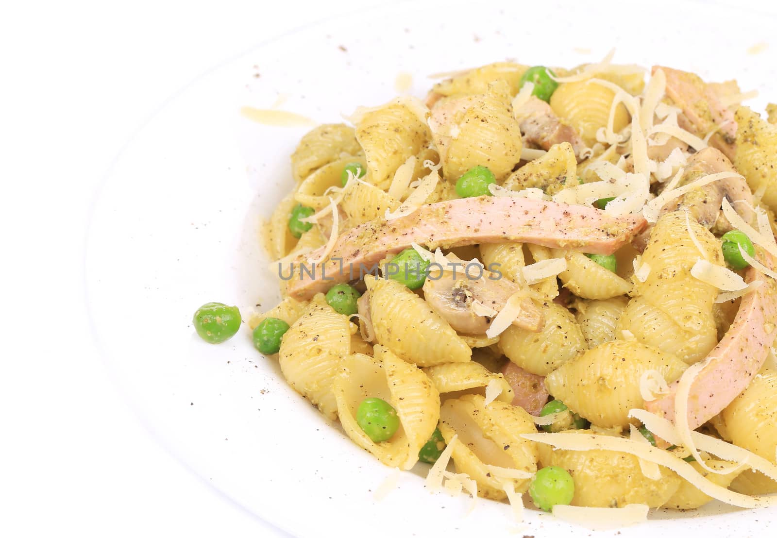 pasta shells with vegetables and sausage on a white plate. isolated on a white background