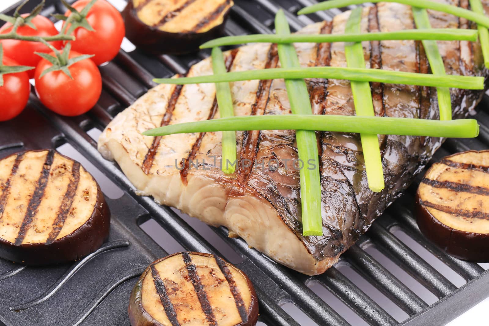 Grilled fish and vegetables. Isolated on a white background.