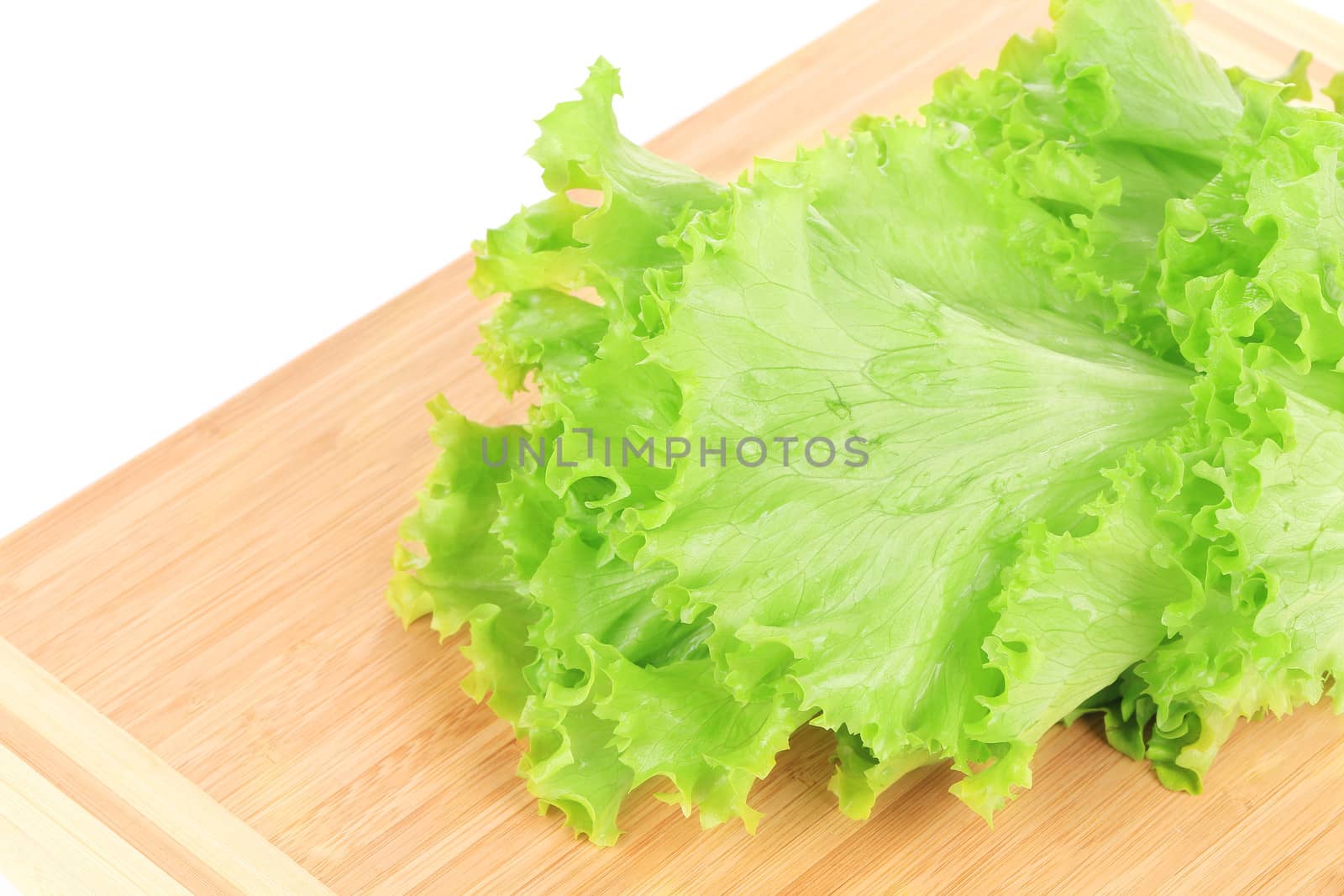 Fresh lettuce on a cutting board. Isolated on a white background.