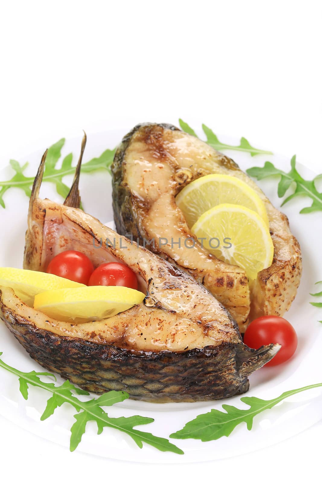 Carp steaks with herbs and lemon. Isolated on a white background.