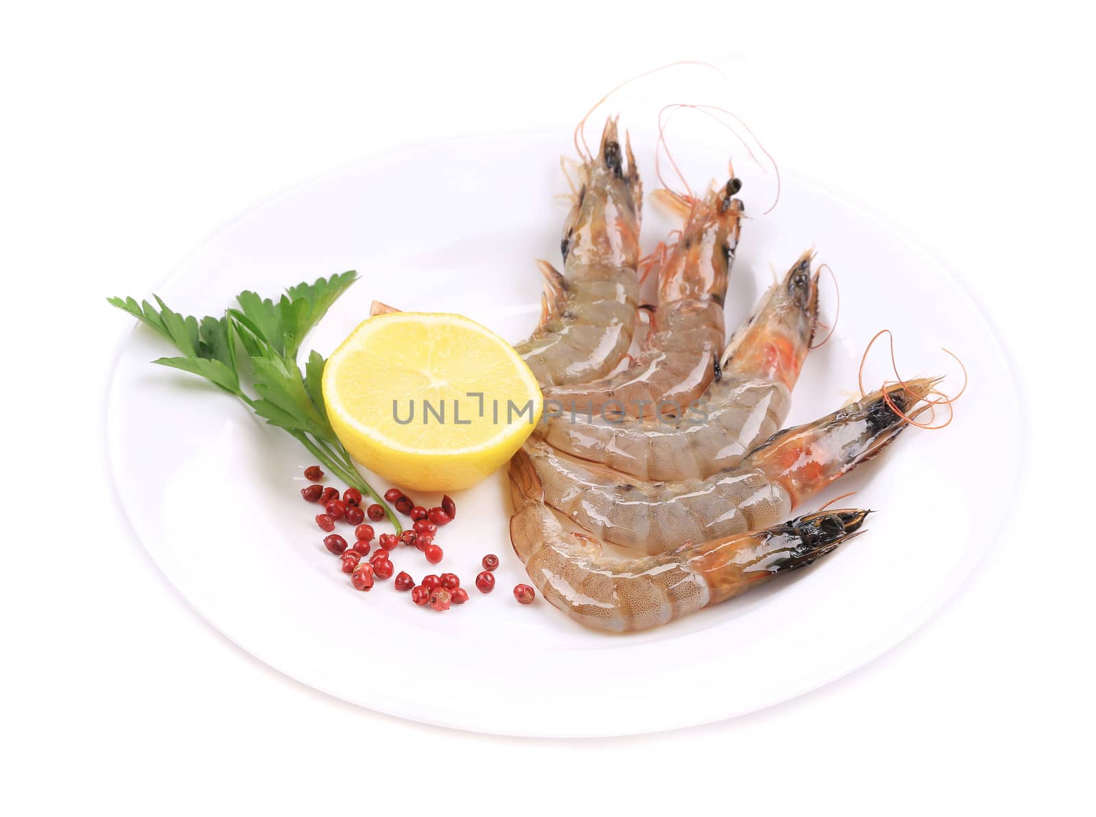 Raw shrimp with lemon and parsley. Isolated on a white background.