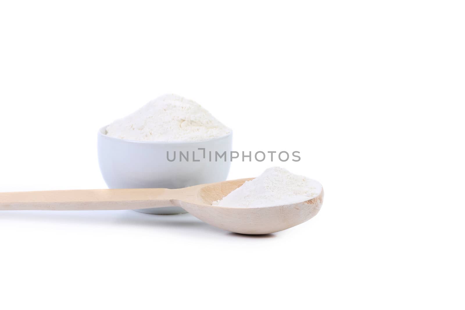 Spoon and bowl with flour. Isolated on a white background.