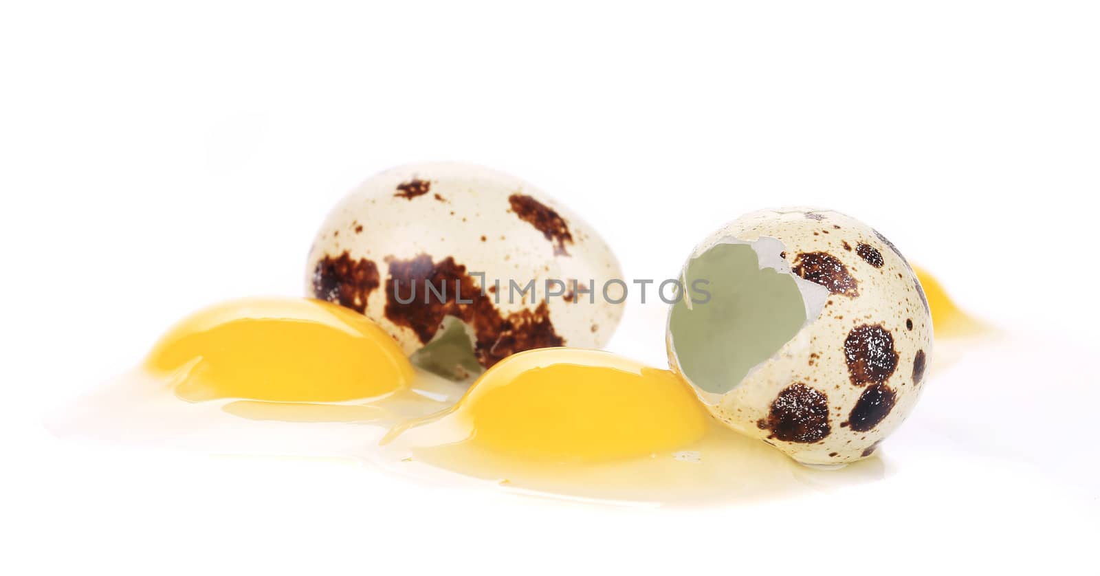 Raw and broken quail eggs. Isolated on a white background.