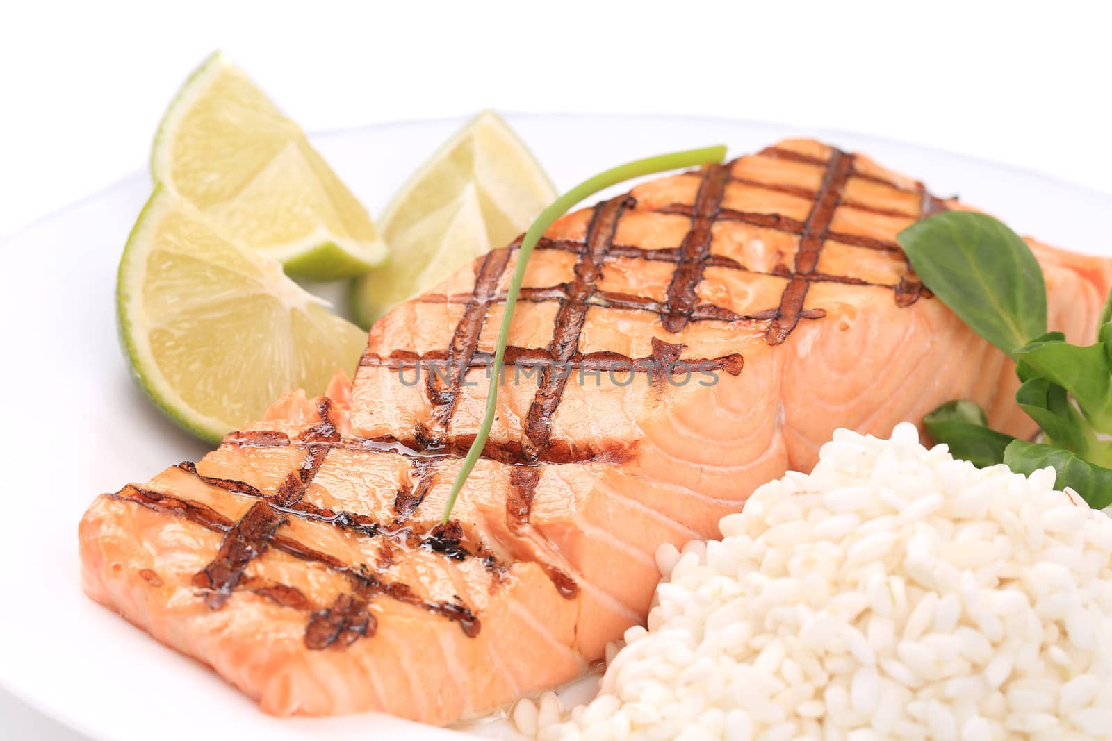 Grilled salmon steak with rice and lime. Isolated on a white background.