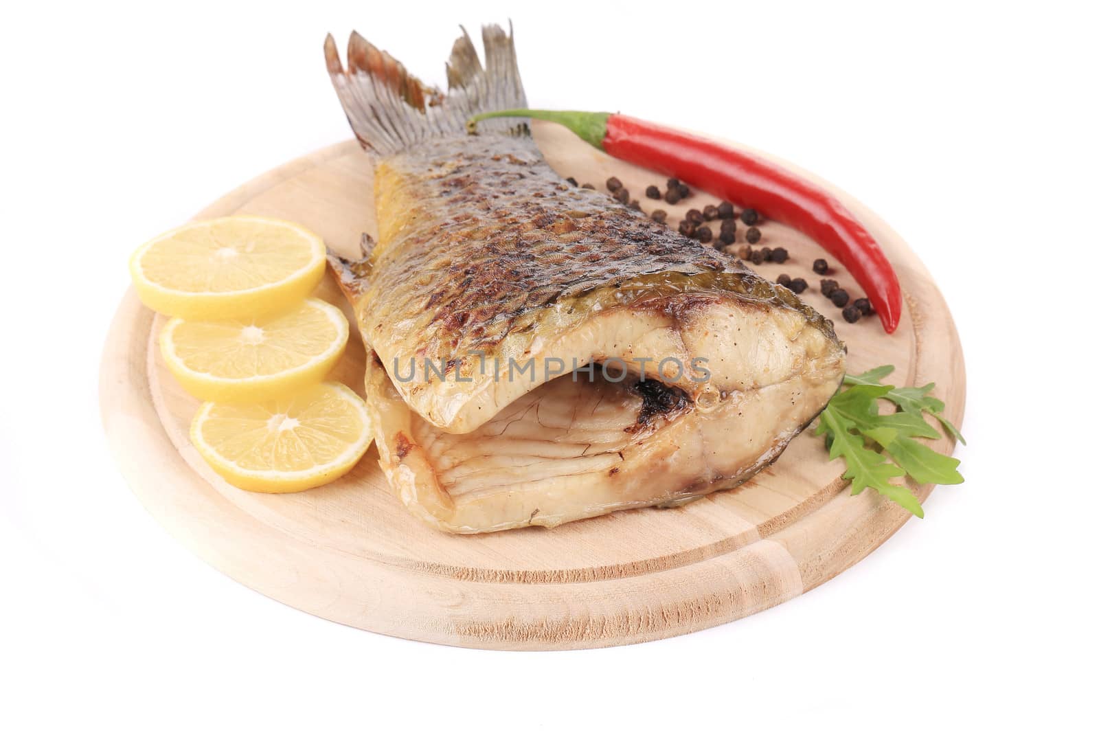 Grilled carp with lemon and peppers. Isolated on a white background.
