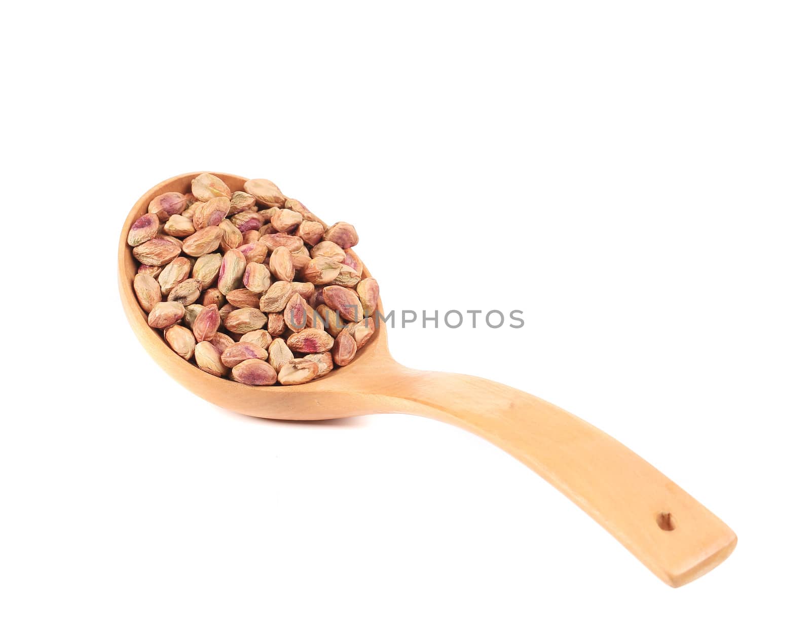 Wooden spoon with peeled pistachios. Isolated on a white background.