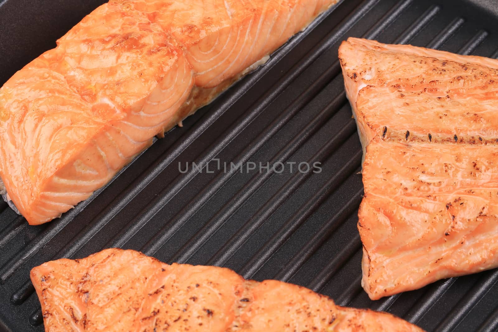 Grilled salmon steaks on frying pan.