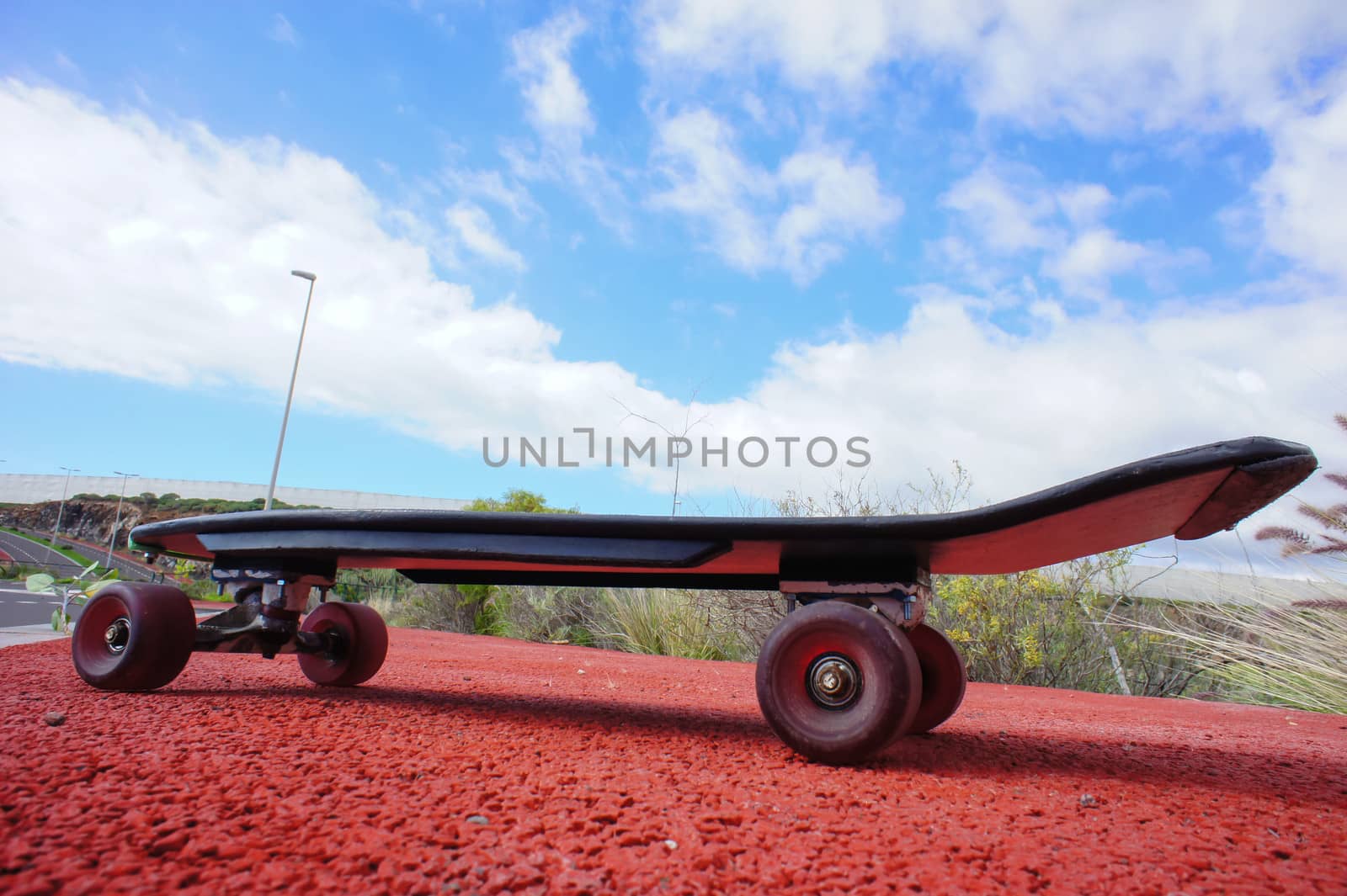 Vintage Style Longboard Black Skateboard on an Empty Asphalt Desert Road