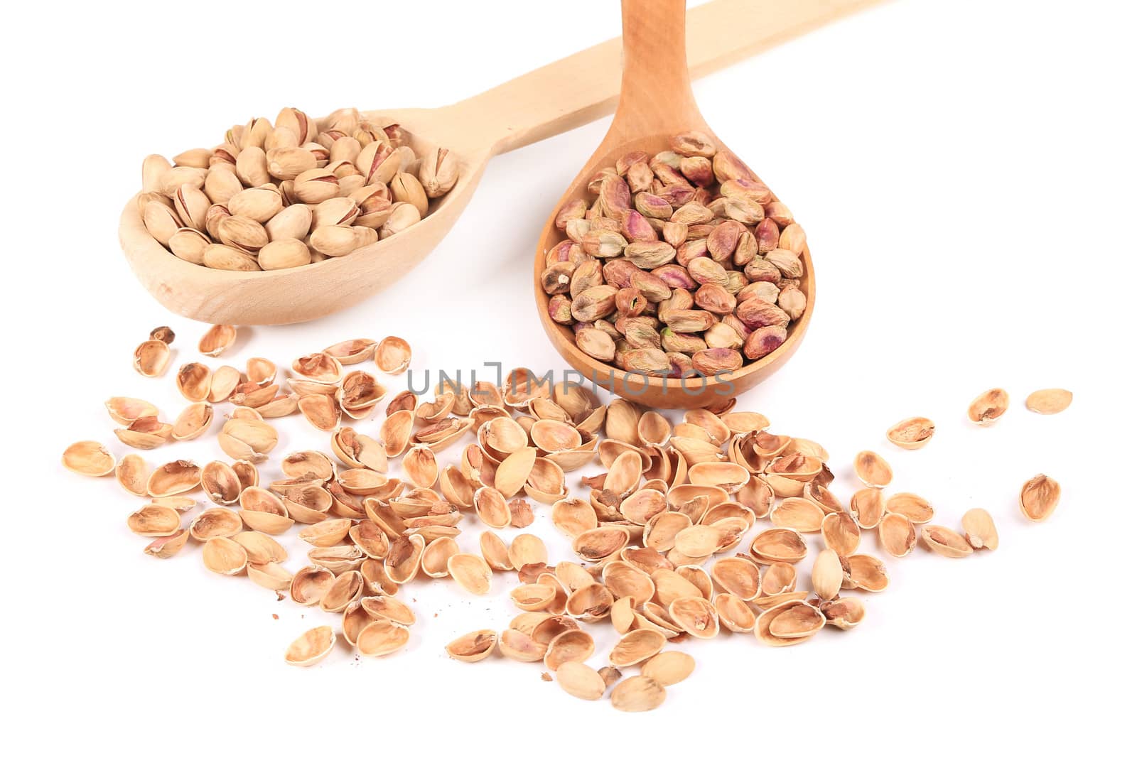 Spoons with pistachios. Isolated on a white background.