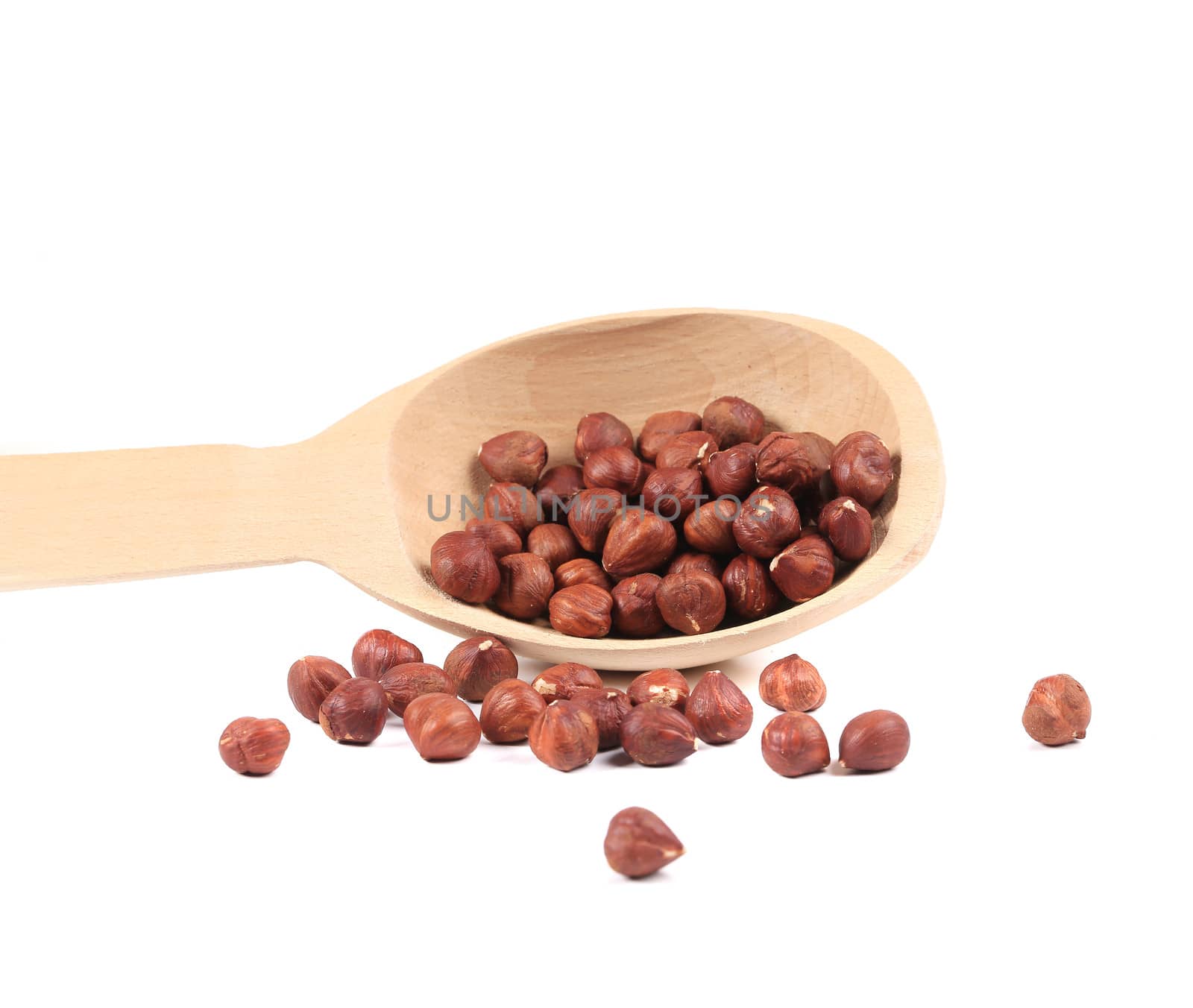 Spoon with hazelnuts close-up. Isolated on a white background.