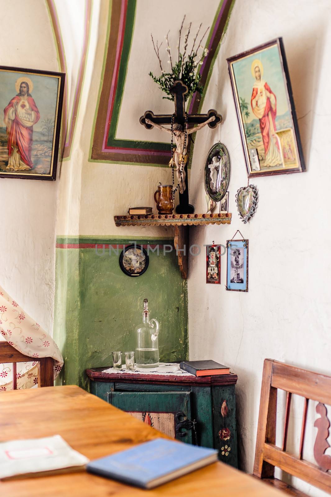 Rural living room with crucifix and religious paintings