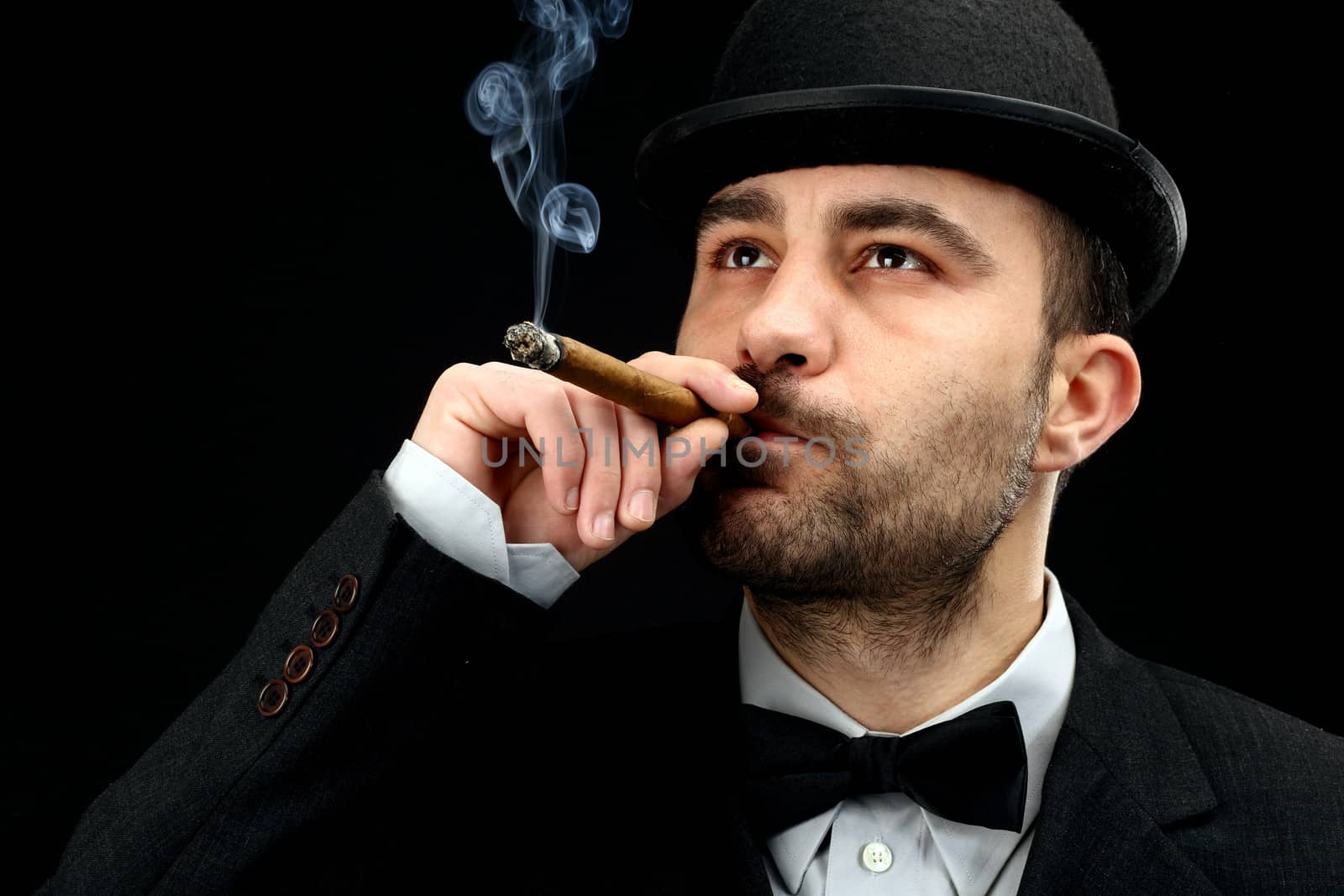 man with bowler hat smoking a  cigar 