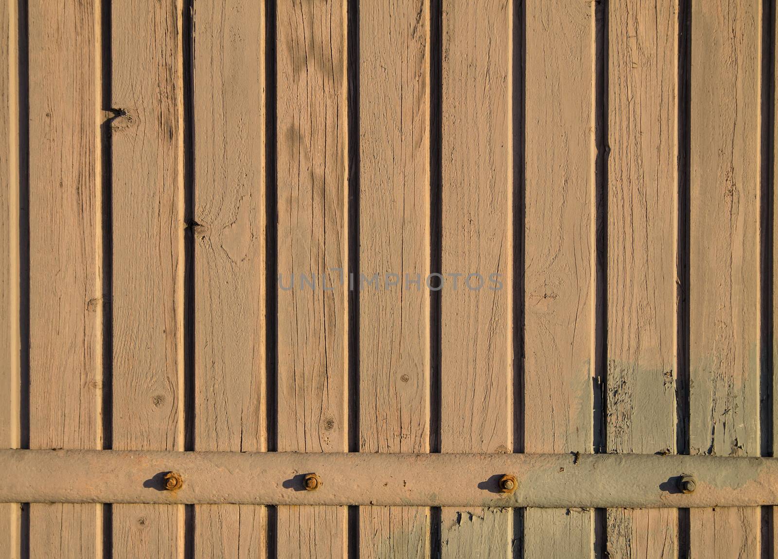 Worn wooden background with a long rusty hinge