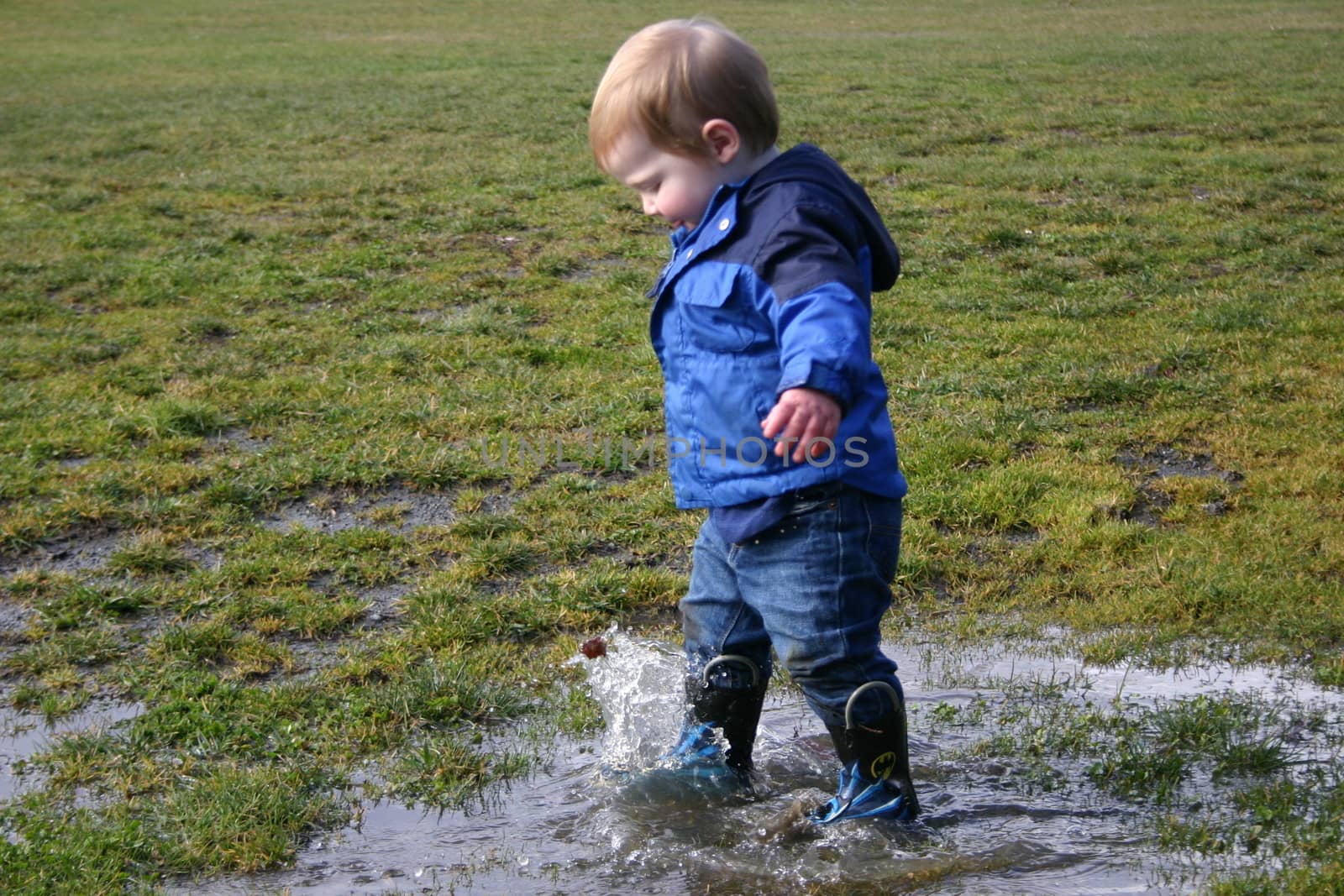 Boy playing in puddle by pelt69