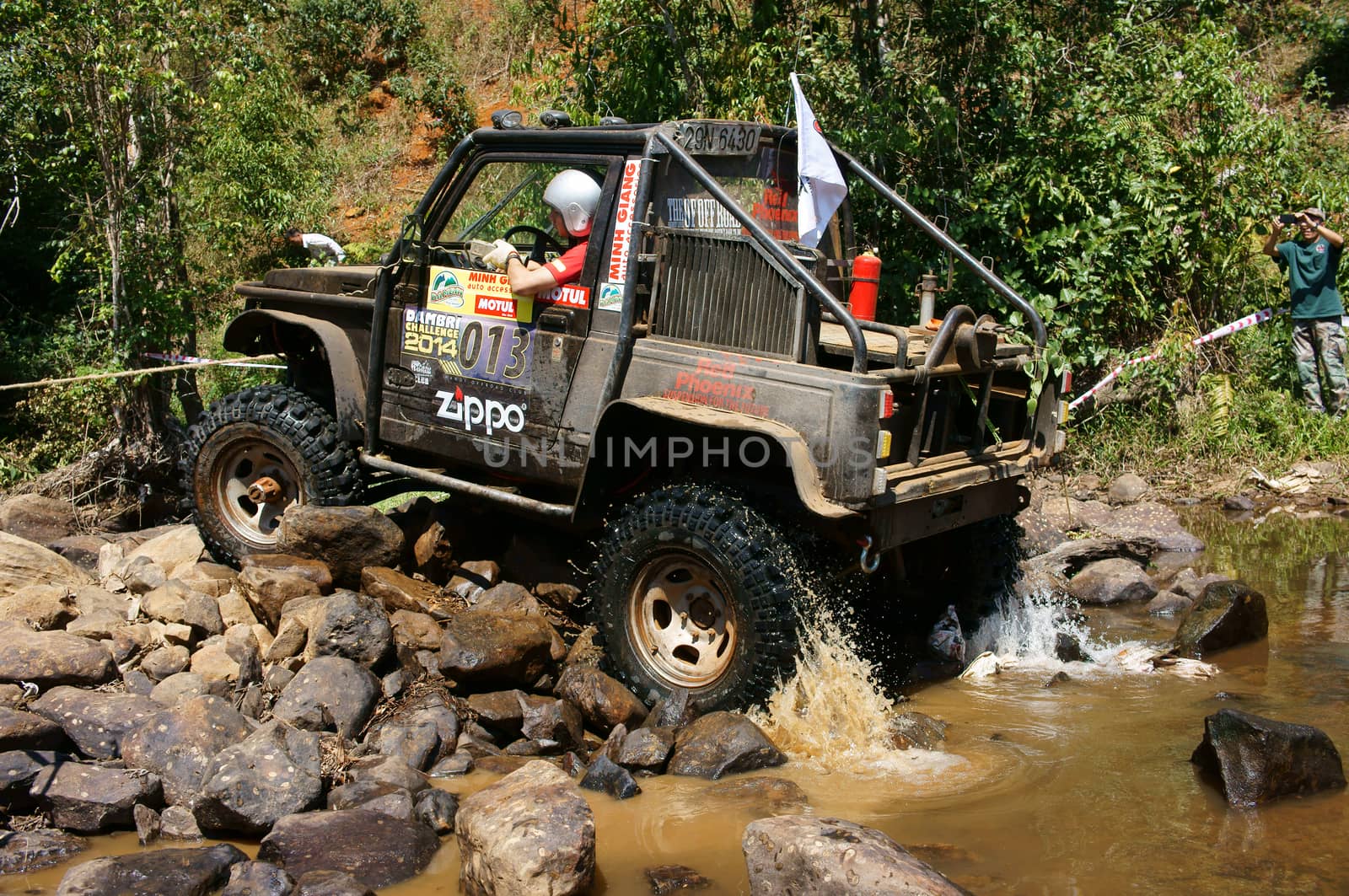 BAO LOC, VIETNAM- FEB 24: Racer at terrain racing car competition,motor cross stream that extreme off road with rock on water, competitor  adventure in championship spirit, Viet Nam, Feb 24, 2014