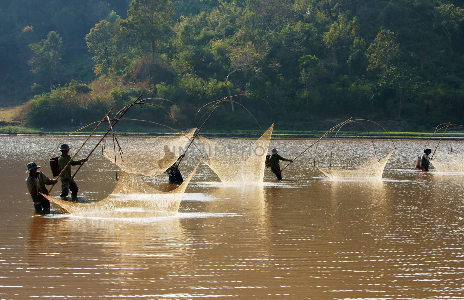 BUON ME THUOT, VIETNAM- FEB 7: People catch fish on ditch, fisherman lifting net from water, lift net is primitive traditional tool, include net, rod, four corner hang up 4 frame, Vietnam, Feb 7, 2014